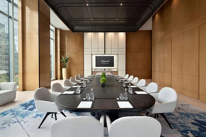 GEORGE Group project image with a long conference table, meeting chairs, a display wall and an enclosed wood-finish room