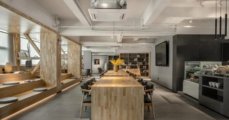 GEORGE Group hospitality reference with a long shared table, stools, surrounding cabinetry and a screen