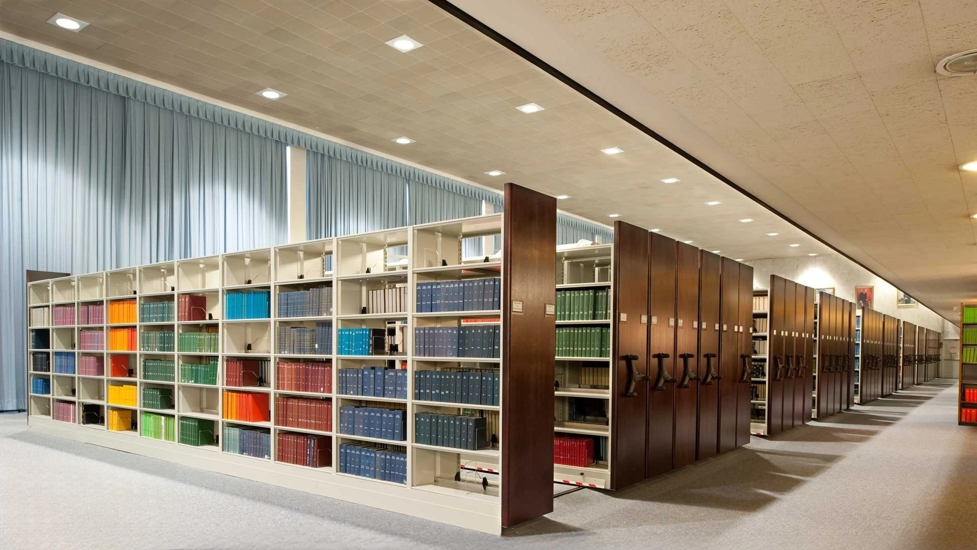 Institutional library with long rows of full-height book shelving